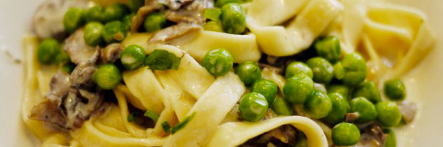 Pasta con funghi, piselli e speck